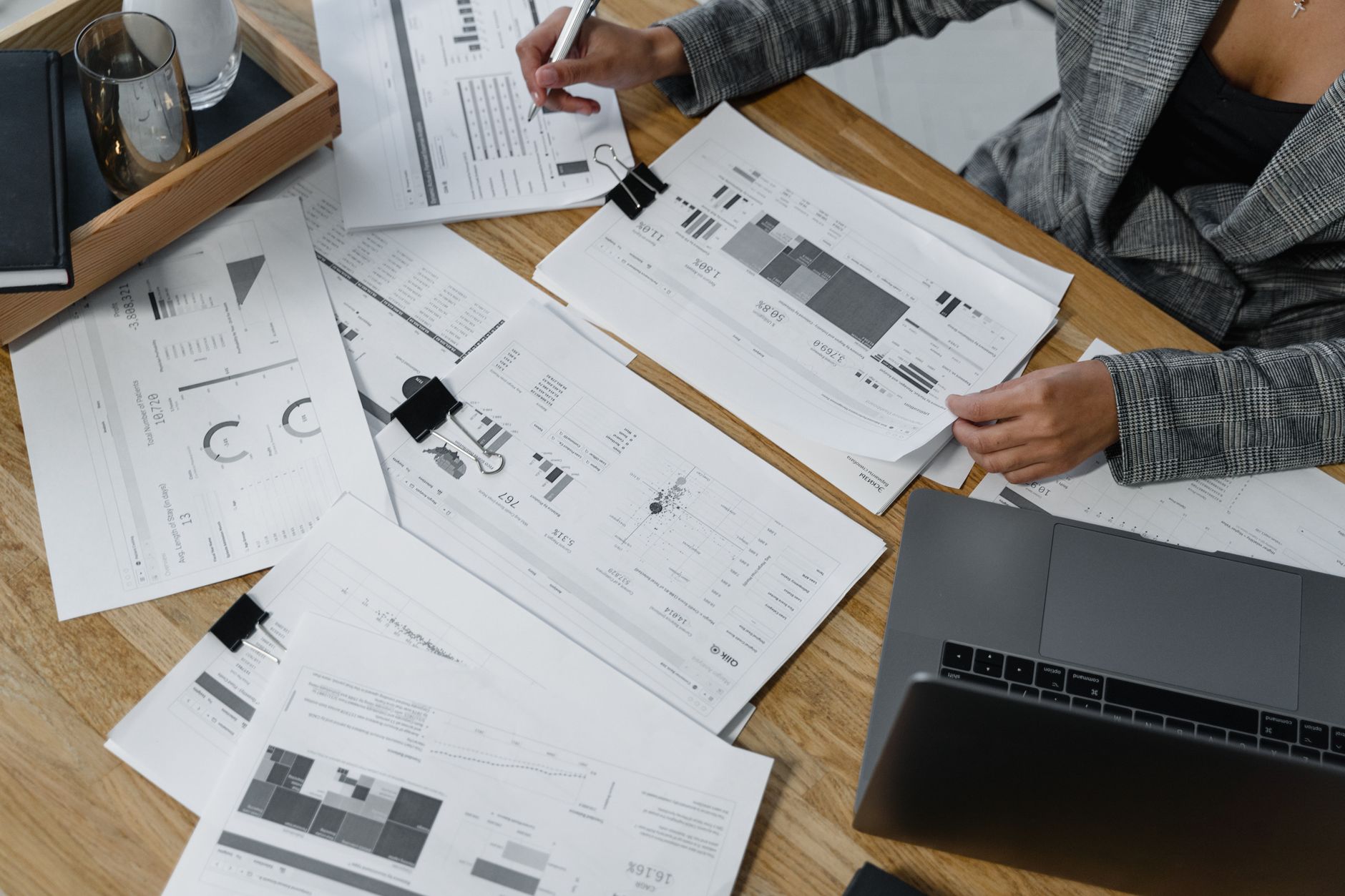 A business person drafting a roadmap on a paper notebook next to analytical charts